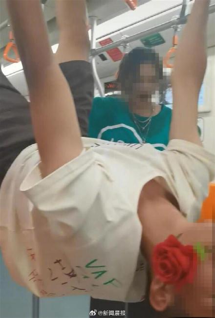 Shanghai Metro men and women wearing clothes with dirty words hanging upside down on the handrail