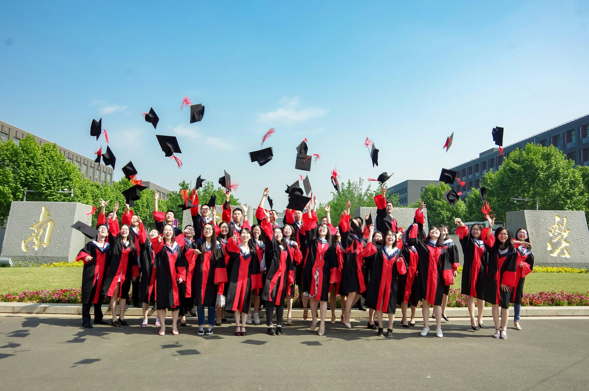 Graduates in gowns toss their caps at a Chinese university ceremony. Photo: HK01