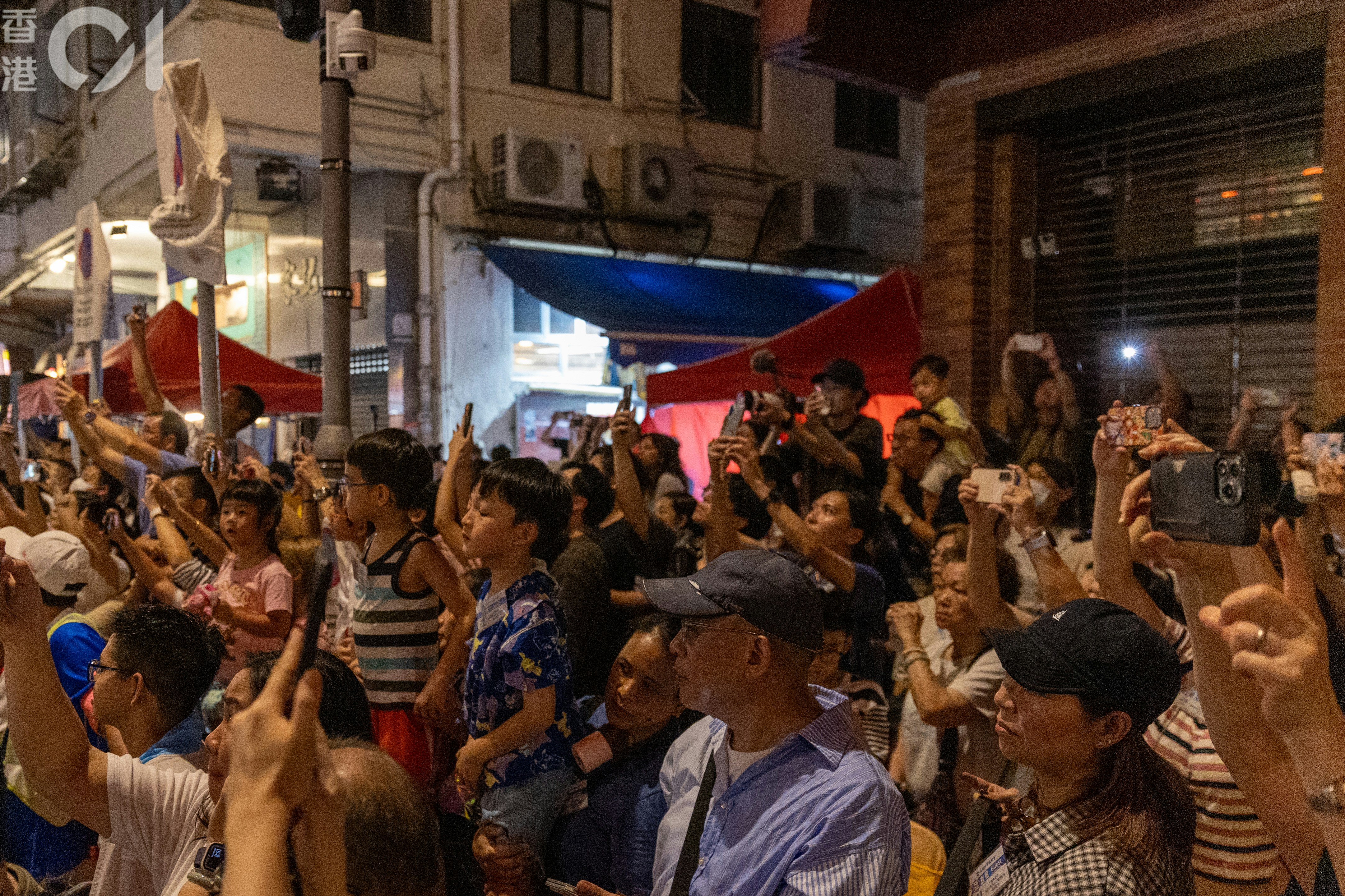 Spectators raise their phones as the dragon passes overhead. Photo: HK01