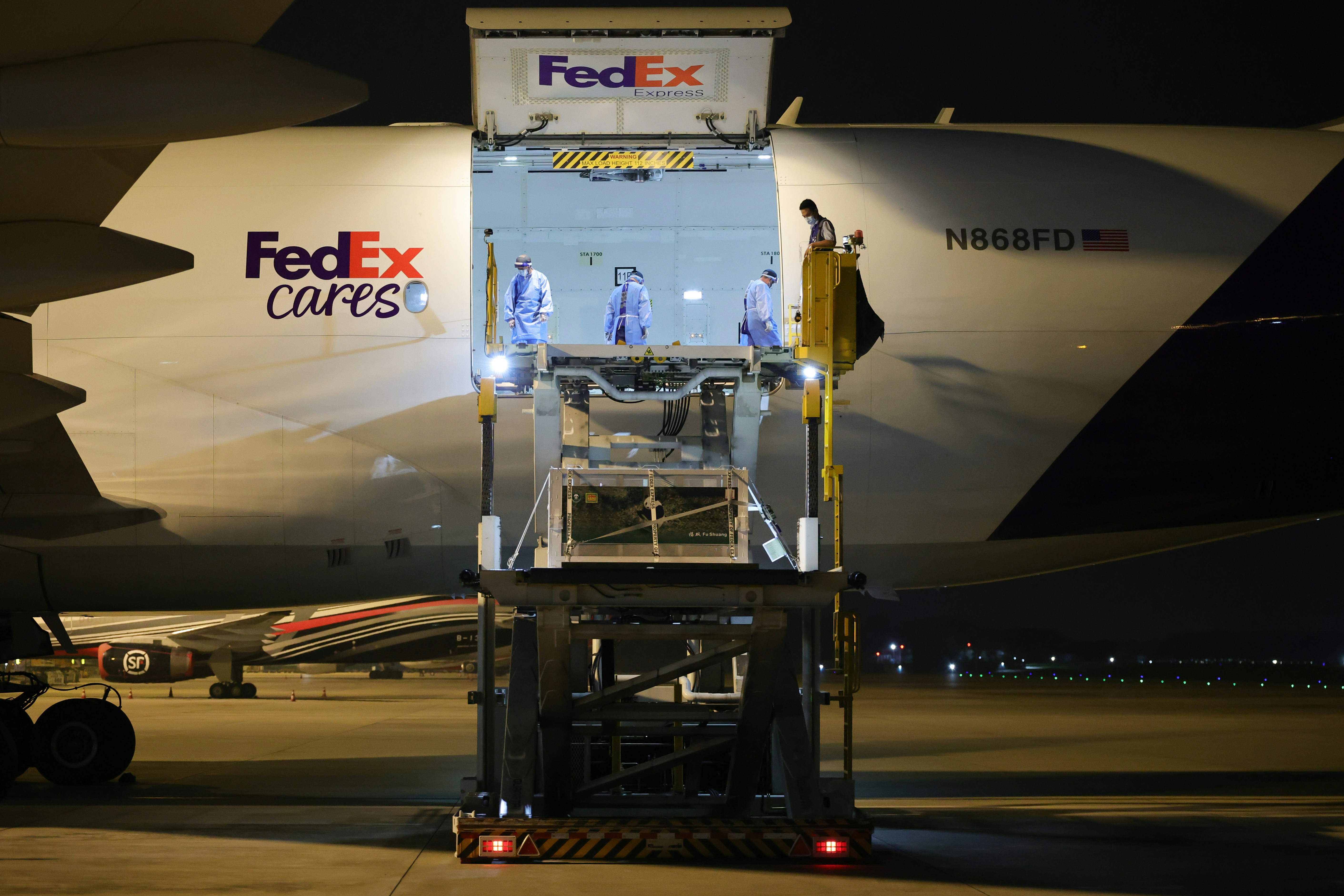 Ground crew load the pandas' FedEx charter at night before the flight from Chengdu. Photo: HK01