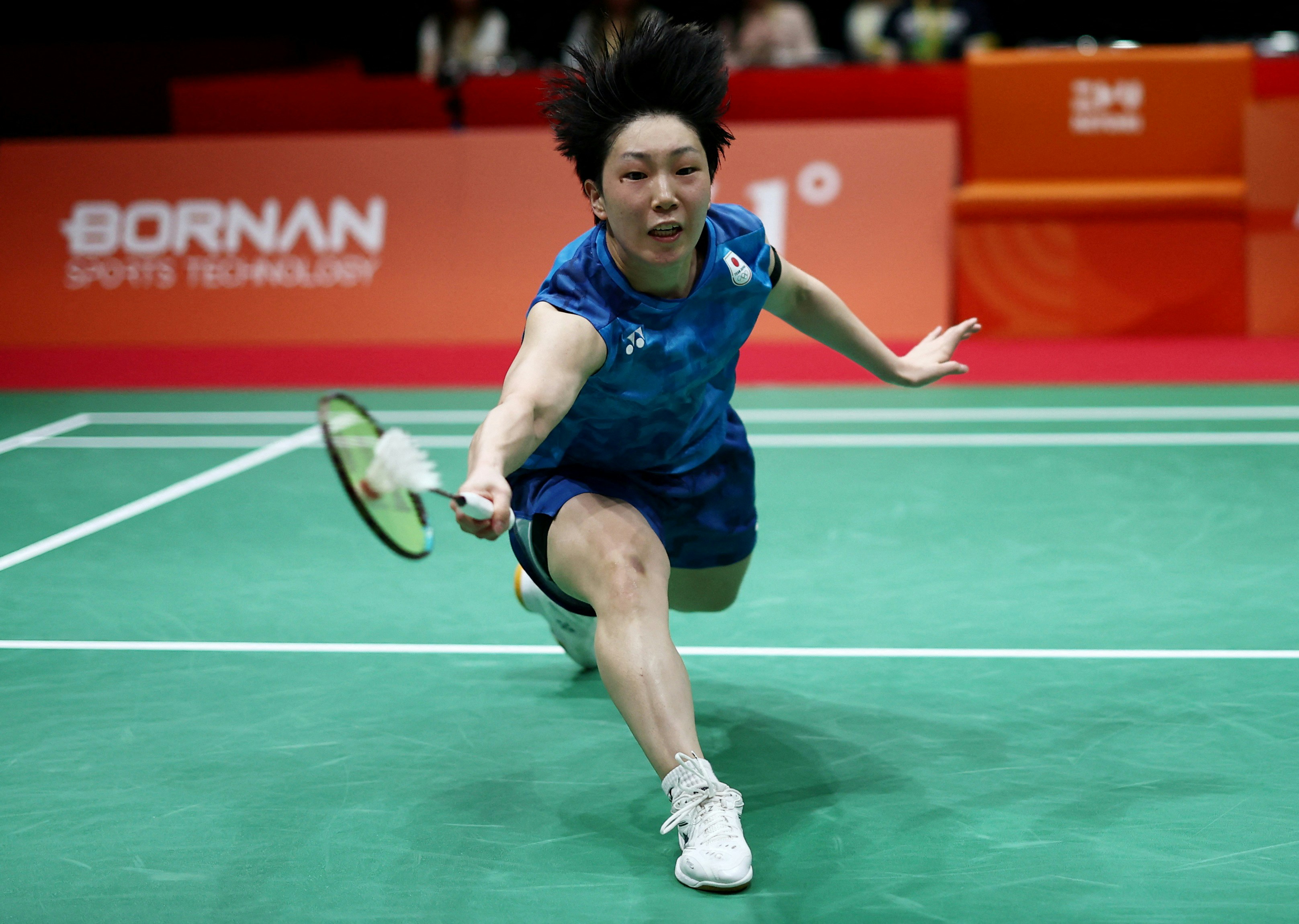 A player lunges for the shuttle on badminton's final day at the Nagoya Asian Games. Photo: HK01