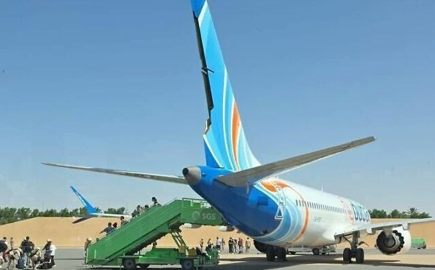 A passenger stands in the aisle of Flydubai flight FZ1073 with bloodstains on his shirt after the attack. Photo: HK01