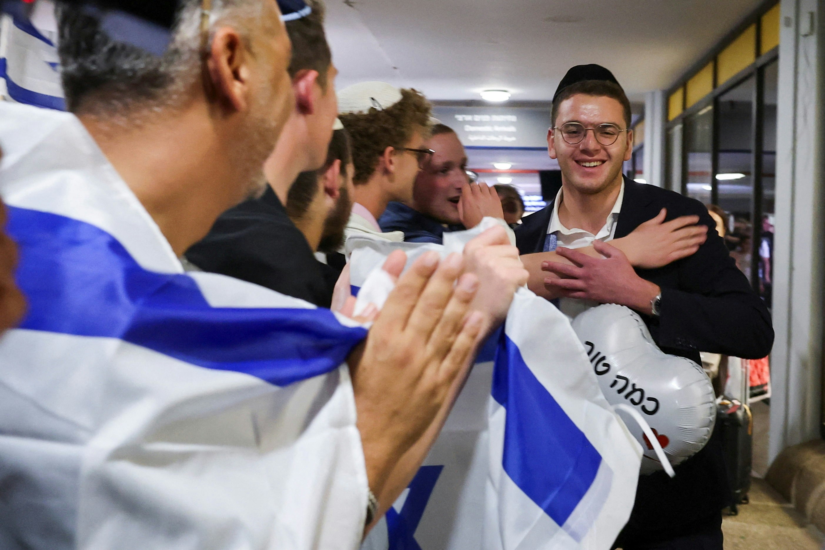 Netanyahu greets returnees at Ben-Gurion airport, where a survivor was met with an Israeli flag. Photo: HK01