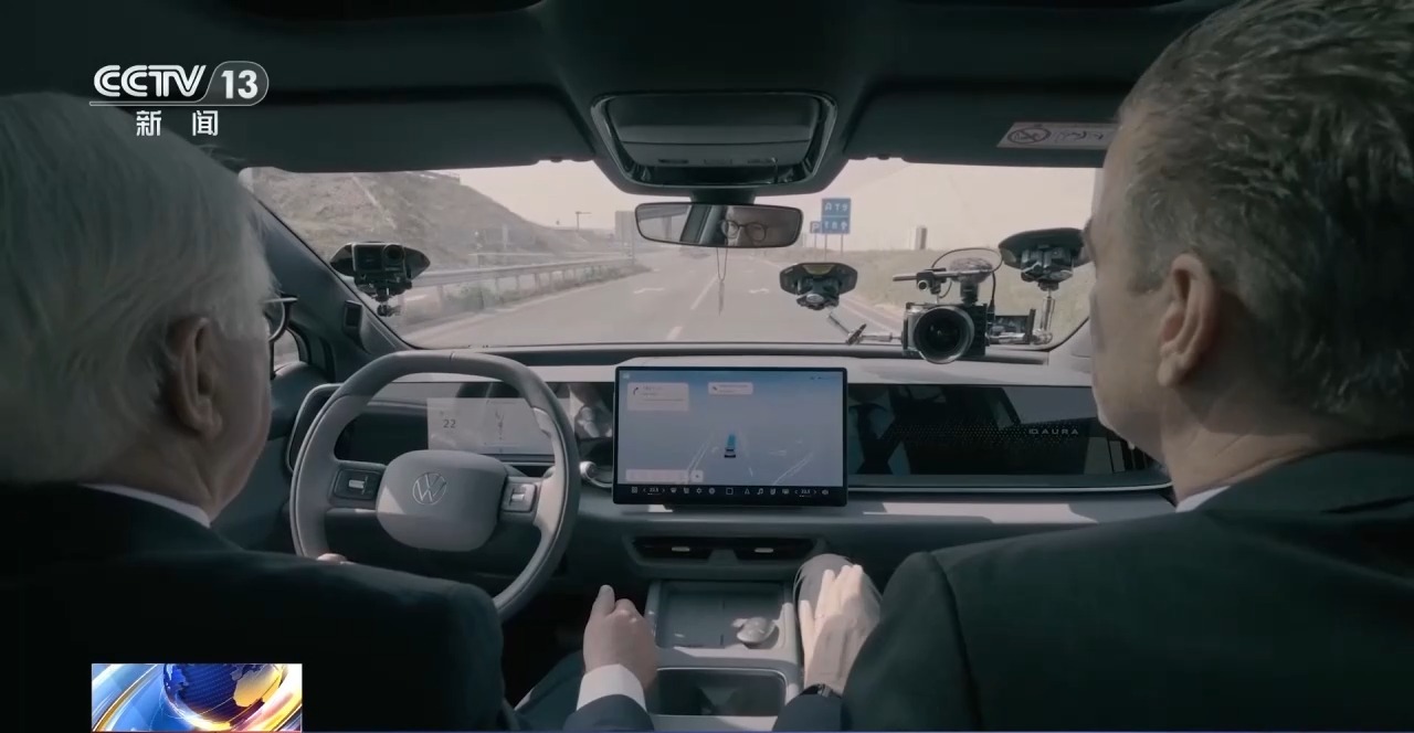 Steinmeier rides in a smart electric car during a demonstration drive, with a 3D road visualization on the dashboard screen. Photo: The Paper