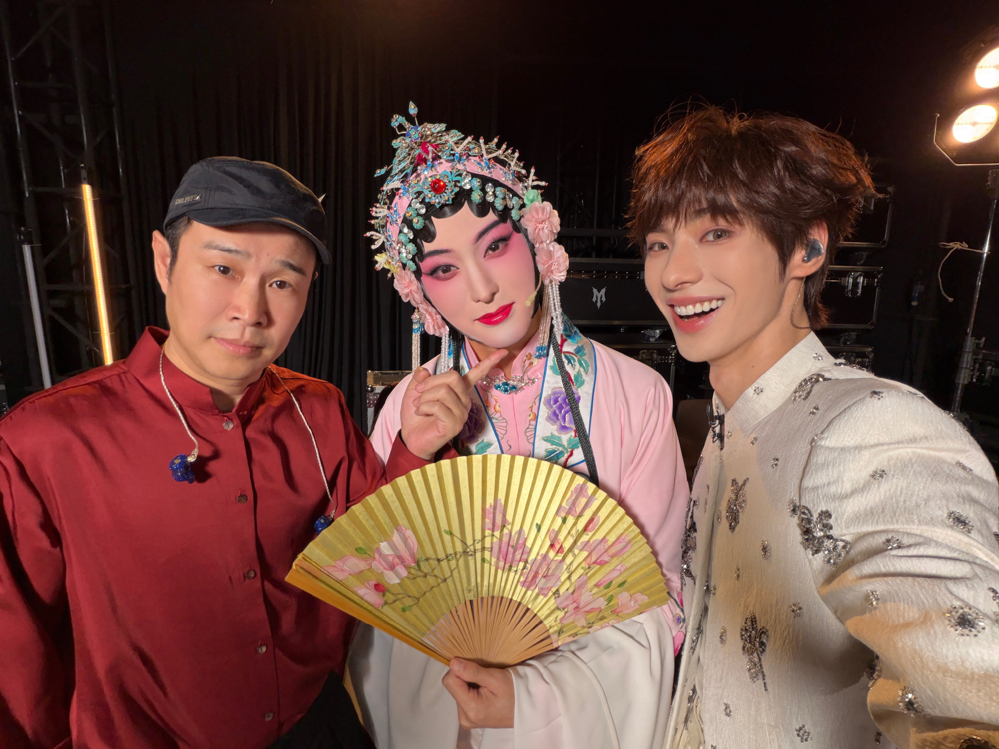 Tang Jiuzhou (centre) in Kunqu costume and makeup backstage, flanked by teammates, after the fifth-round stage. Photo: @颜安YA