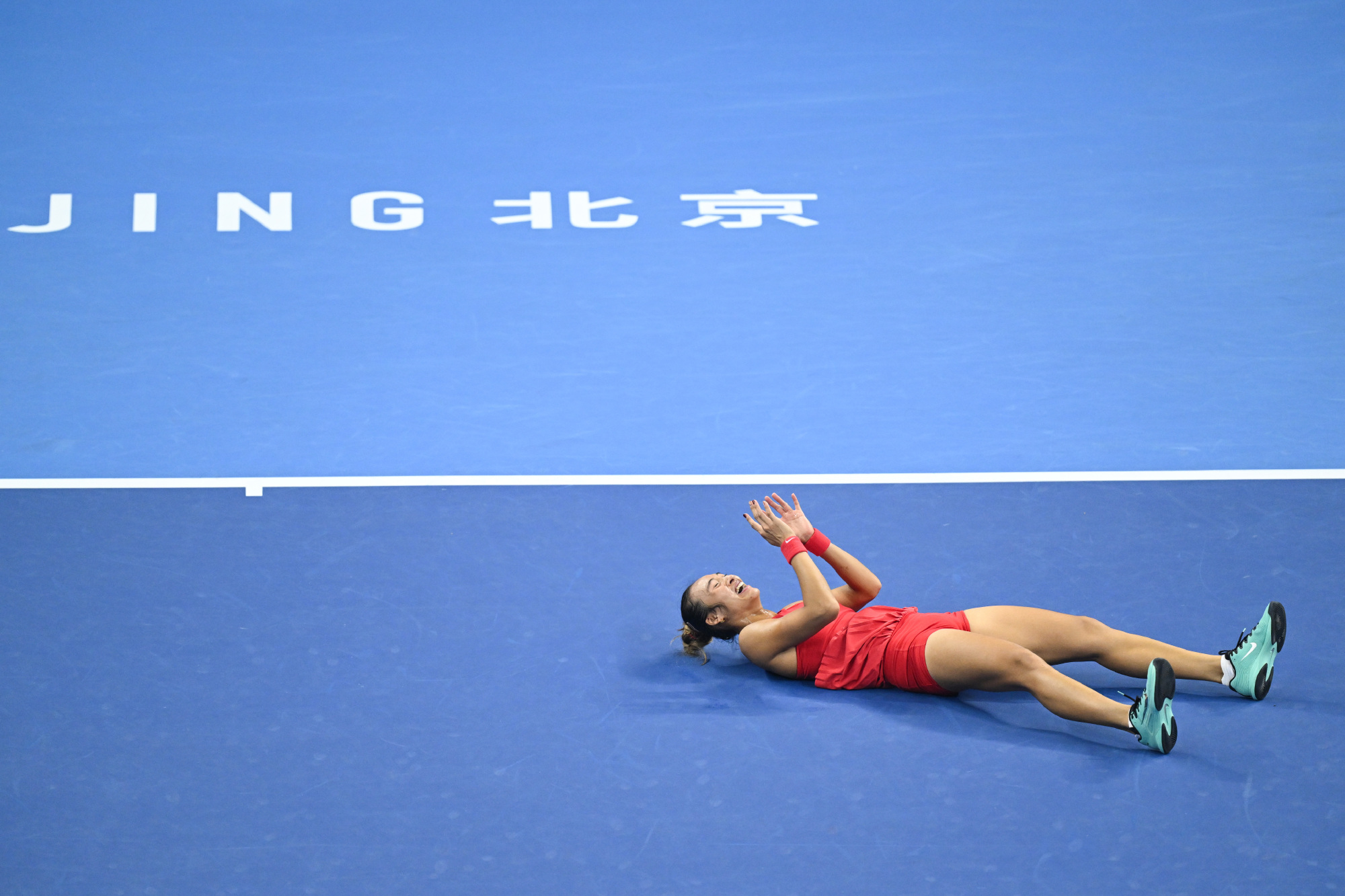 Zheng Qinwen lies back on the court after match point in the final. Photo: @WTA国际女子网球协会