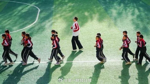 Pupils walk in line across a primary school playground — a scene growing rarer as rural campuses close. Photo: @大皖新闻
