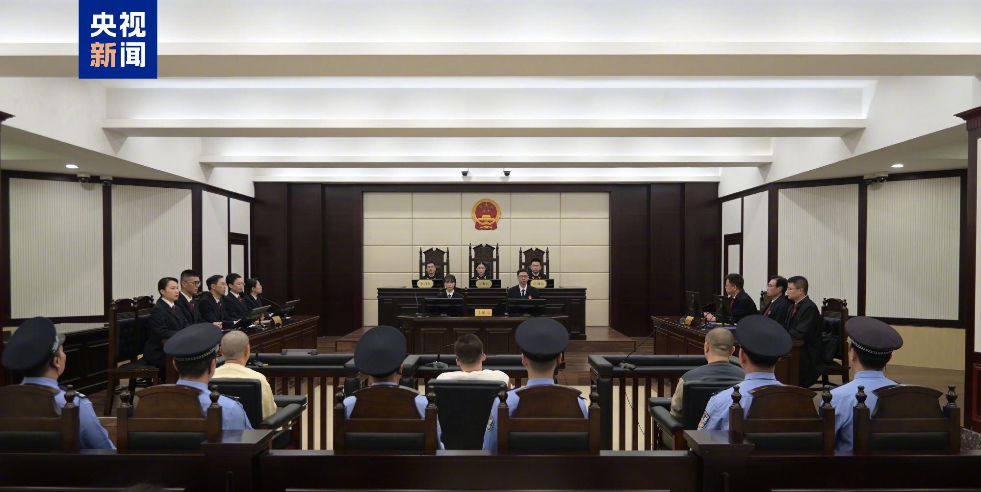 The bench at the first-instance sentencing in Quanzhou, with defendants and officers in the foreground. Photo: @法治网