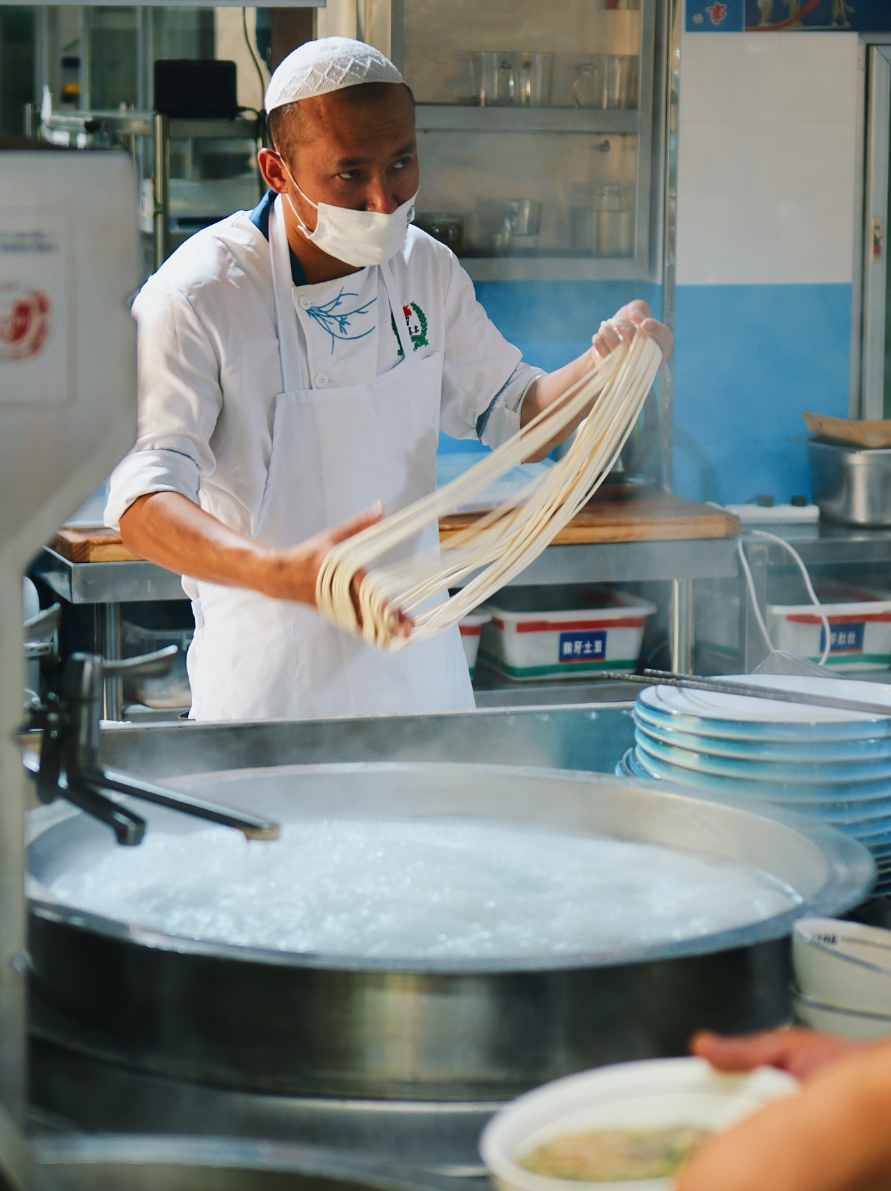 A chef stretches dough into strands at a Qinghai lamian kitchen, the pulling motion that gives the noodle its name. Photo: @蓝绿那点事