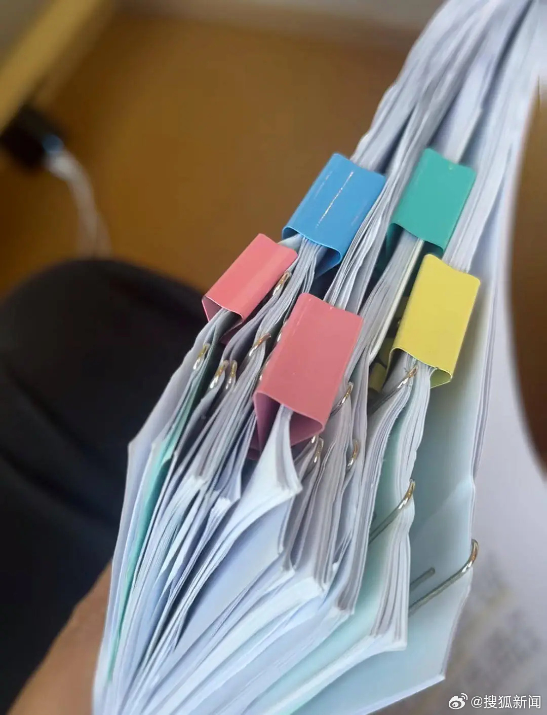 The stack of paperwork behind the suit: Chen Shiyu's complaint, prepared with a lawyer and an AI assistant. Photo: @搜狐新闻