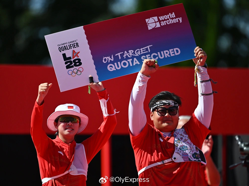 Two Chinese archers hold up a placard reading 'Olympic Games Qualifier LA28 — Quota Secured' after the mixed-team final. Photo: @OlyExpress