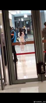 In a shopping mall in Wuhan, Hubei, a young woman was seen standing in the middle of the mall, completely naked.